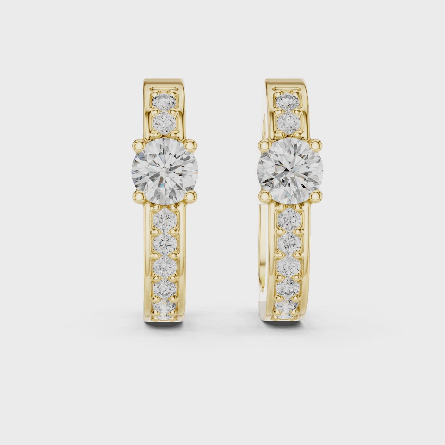Rose gold diamond hoop earrings with a central round diamond and smaller diamonds along the band.